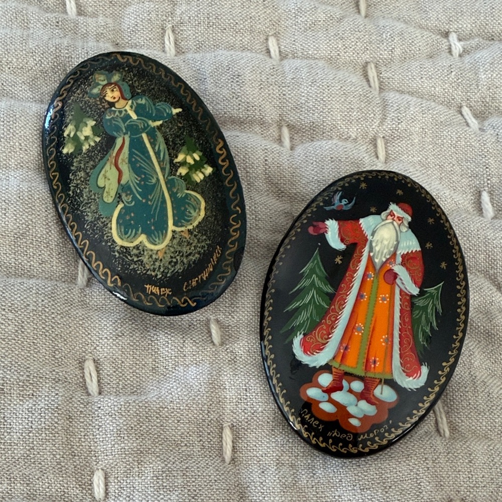 Russian black lacquer Hand-Painted Holiday Brooch Set of 2. Both are signed.
